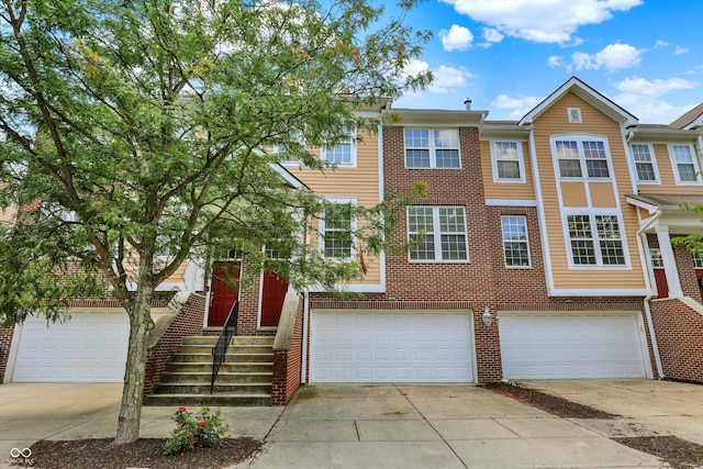 5674 Brownstone Dr, Indianapolis, IN 46220 - view of front of home with driveway, an attached garage, and brick siding