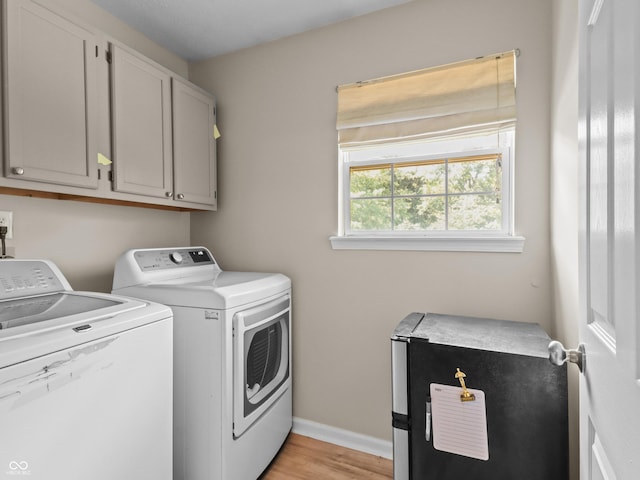5626 Prince Woods Cir, Indianapolis, IN 46224 - laundry area featuring washer and clothes dryer, cabinet space, and light wood finished floors
