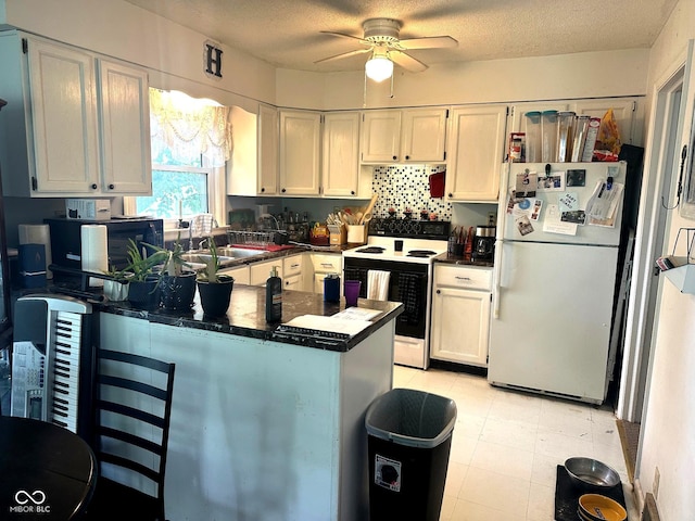 1000 Meadow Ln, Greencastle, IN 46135 - kitchen with white appliances, dark countertops, a peninsula, ceiling fan, and white cabinets