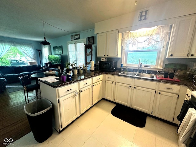 1000 Meadow Ln, Greencastle, IN 46135 - kitchen featuring a peninsula, healthy amount of natural light, black microwave, and decorative light fixtures