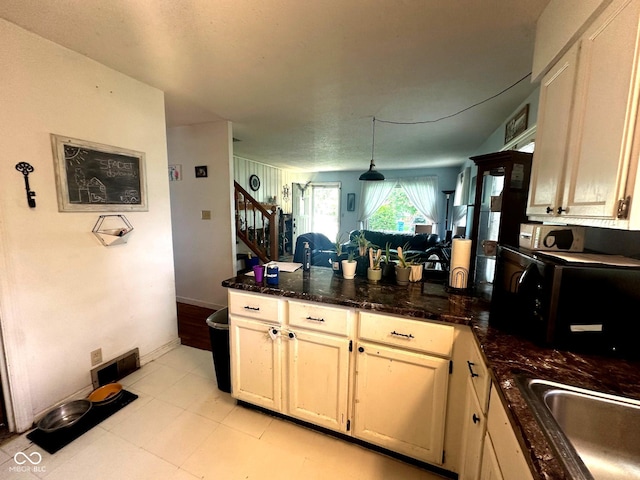 1000 Meadow Ln, Greencastle, IN 46135 - kitchen featuring a peninsula, dark stone counters, and pendant lighting