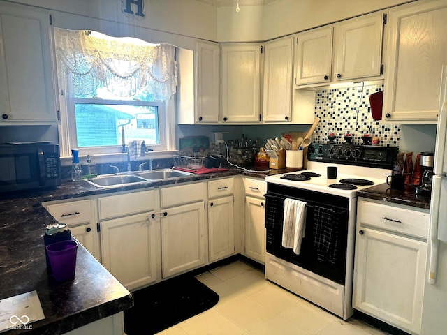 1000 Meadow Ln, Greencastle, IN 46135 - kitchen with black microwave, range with electric stovetop, white cabinets, and light tile patterned floors