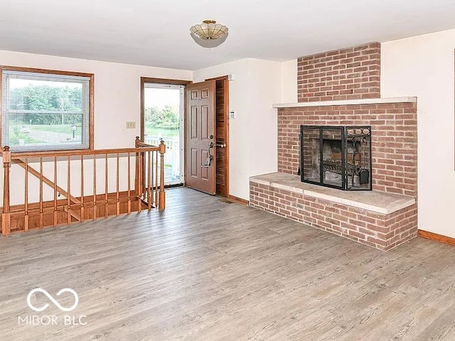 18378 Southeastern Pkwy, Fortville, IN 46040 - unfurnished living room featuring wood finished floors, plenty of natural light, and a fireplace