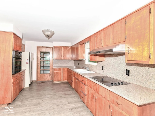18378 Southeastern Pkwy, Fortville, IN 46040 - kitchen featuring black appliances, under cabinet range hood, light wood-type flooring, tasteful backsplash, and light countertops
