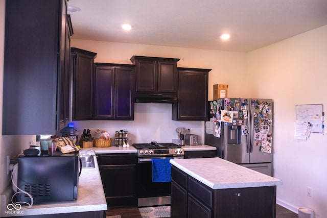 907 Ram Dr, Franklin, IN 46131 - kitchen featuring appliances with stainless steel finishes, light countertops, dark wood-type flooring, under cabinet range hood, and a kitchen island