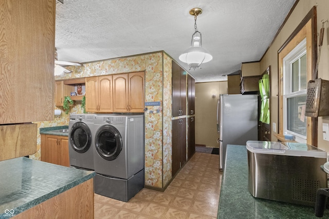 3534 Carr Ave, Indianapolis, IN 46221 - laundry area with a textured ceiling, light floors, washing machine and clothes dryer, wallpapered walls, and cabinet space
