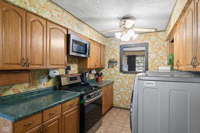 3534 Carr Ave, Indianapolis, IN 46221 - kitchen with stainless steel appliances, washer / clothes dryer, wallpapered walls, a textured ceiling, and brown cabinets