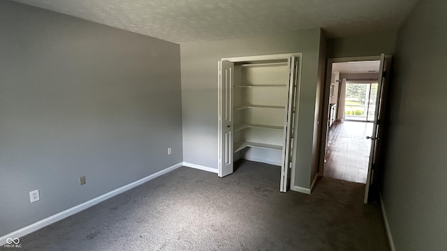 2083 Kerns Ct, Carmel, IN 46280 - unfurnished bedroom with dark carpet, a closet, and a textured ceiling