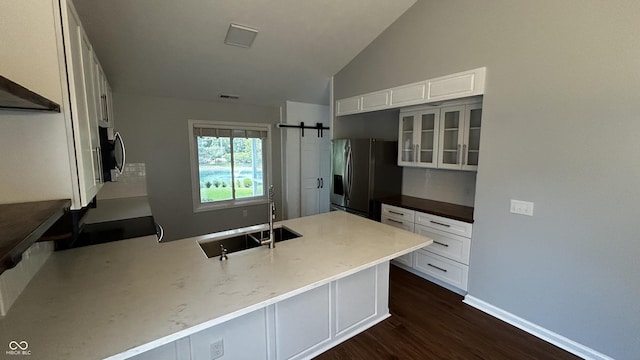 2083 Kerns Ct, Carmel, IN 46280 - kitchen with stainless steel appliances, dark wood-style floors, vaulted ceiling, a peninsula, and white cabinets