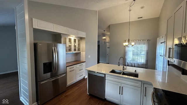 2083 Kerns Ct, Carmel, IN 46280 - kitchen with appliances with stainless steel finishes, a chandelier, dark wood finished floors, a peninsula, and decorative backsplash