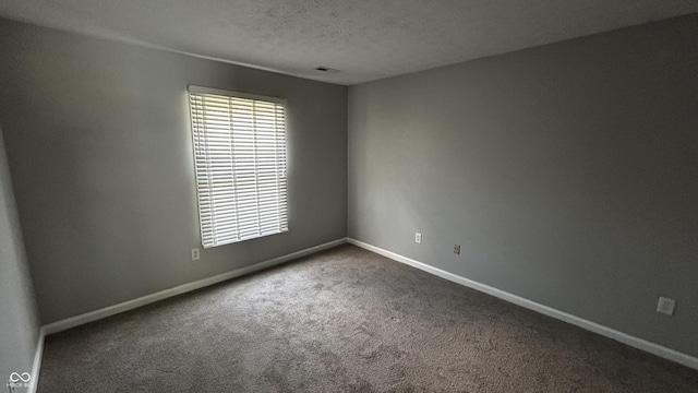 2083 Kerns Ct, Carmel, IN 46280 - unfurnished room featuring dark carpet, plenty of natural light, and a textured ceiling