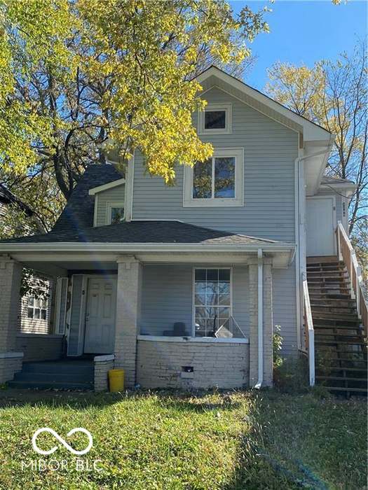 2249 E Brookside Ave, Indianapolis, IN 46218 - view of front of property with stairs, a porch, brick siding, and a front yard