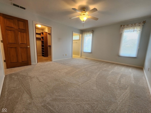 1633 Belfield St, Indianapolis, IN 46217 - unfurnished bedroom featuring a walk in closet, carpet floors, a closet, and ceiling fan