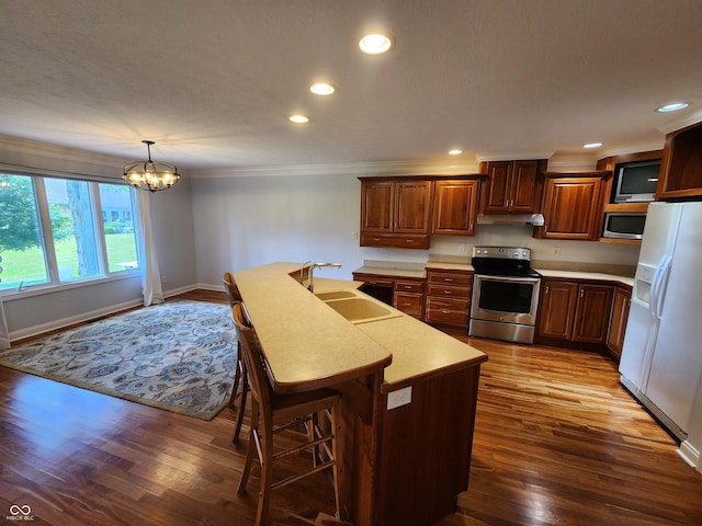 1633 Belfield St, Indianapolis, IN 46217 - kitchen with appliances with stainless steel finishes, under cabinet range hood, crown molding, light countertops, and a chandelier