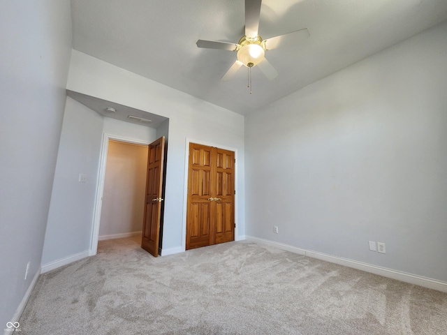 1633 Belfield St, Indianapolis, IN 46217 - unfurnished bedroom featuring light carpet, a closet, and a ceiling fan