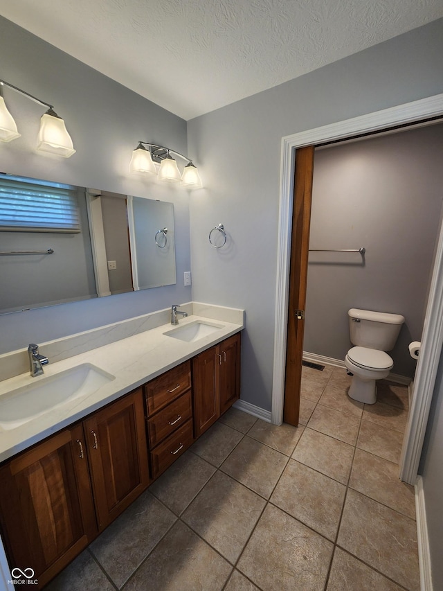 1633 Belfield St, Indianapolis, IN 46217 - full bathroom featuring double vanity, tile patterned flooring, and a textured ceiling