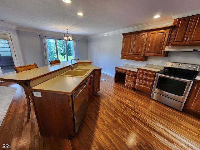 1633 Belfield St, Indianapolis, IN 46217 - kitchen with stainless steel appliances, under cabinet range hood, crown molding, dark wood-style flooring, and a kitchen breakfast bar