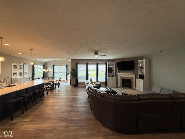 19280 Scofield Ridge Blvd, Westfield, IN 46062 - living area with a textured ceiling, a fireplace, wood finished floors, ceiling fan, and recessed lighting