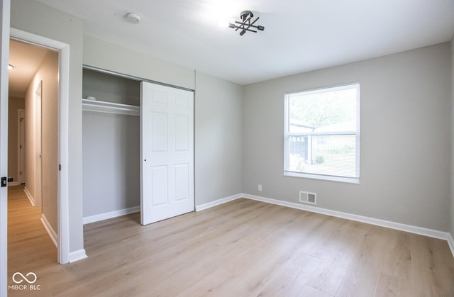 8650 Holliday Dr, Indianapolis, IN 46260 - unfurnished bedroom with light wood-style floors and a closet