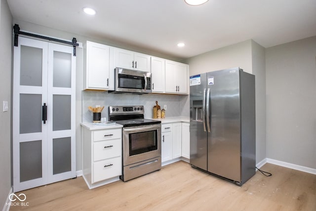 8650 Holliday Dr, Indianapolis, IN 46260 - kitchen with stainless steel appliances, light wood-style floors, white cabinets, light countertops, and recessed lighting