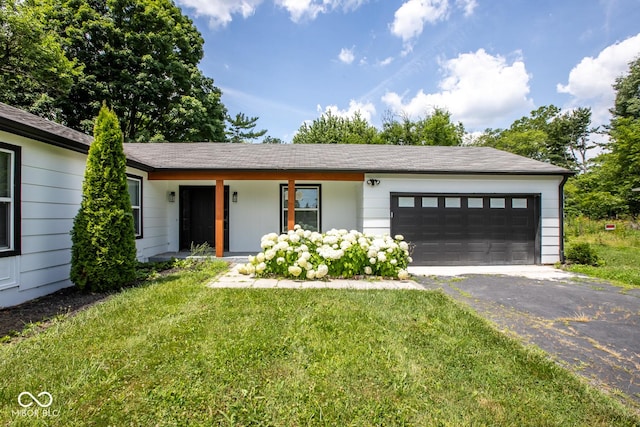 8650 Holliday Dr, Indianapolis, IN 46260 - single story home featuring asphalt driveway, a garage, a front yard, and covered porch