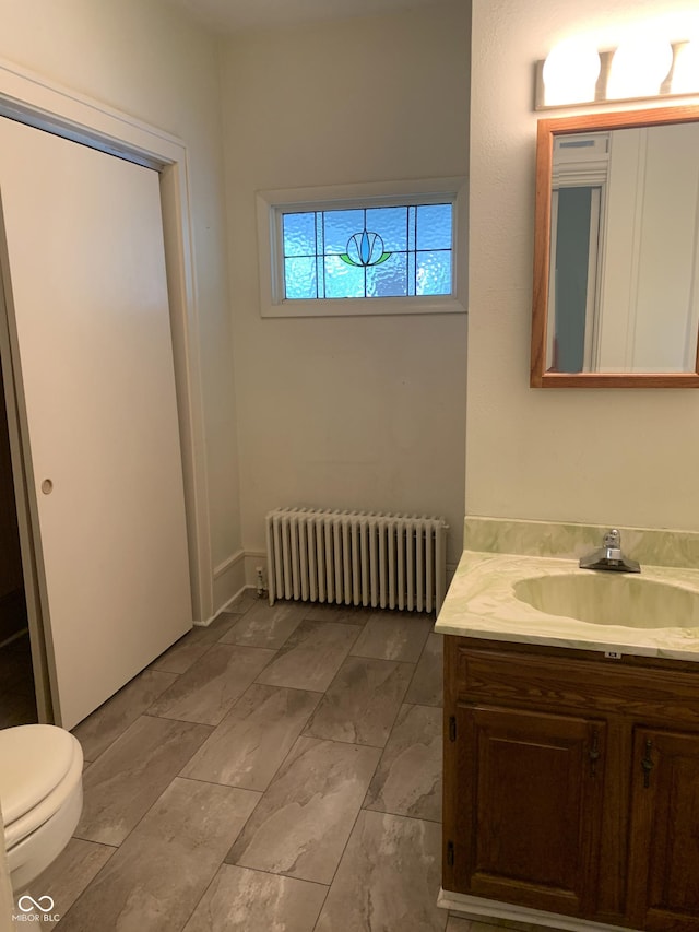 236 N Maple St, Dana, IN 47847 - bathroom with radiator heating unit, vanity, and marble look tiles