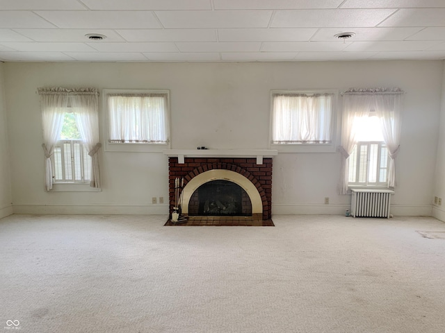 236 N Maple St, Dana, IN 47847 - unfurnished living room featuring radiator heating unit, plenty of natural light, and carpet