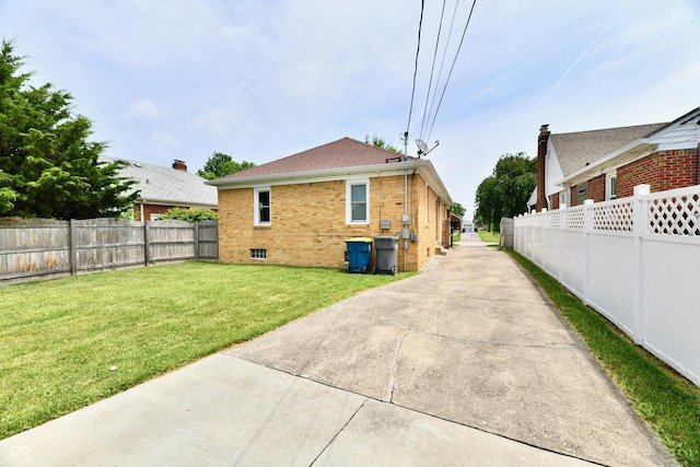 1336 N Butler Ave, Indianapolis, IN 46219 - view of side of property with brick siding, a fenced backyard, and roof with shingles