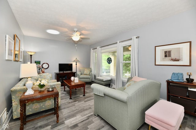 1336 N Butler Ave, Indianapolis, IN 46219 - living room featuring a ceiling fan, light wood finished floors, and a textured ceiling