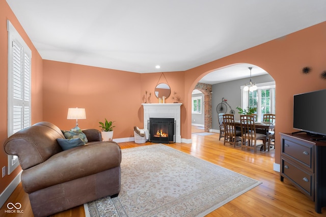 4224 River Rd, Columbus, IN 47203 - living area featuring arched walkways, light wood-type flooring, and a warm lit fireplace