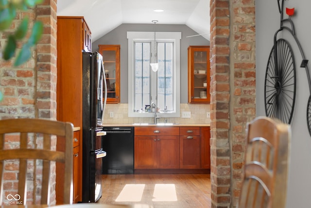 4224 River Rd, Columbus, IN 47203 - kitchen with black appliances, brown cabinetry, light wood-type flooring, glass insert cabinets, and vaulted ceiling