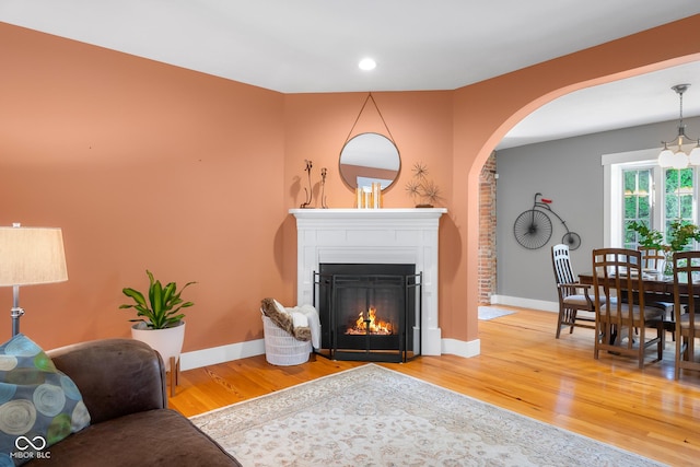 4224 River Rd, Columbus, IN 47203 - living room with wood finished floors, a lit fireplace, arched walkways, and recessed lighting