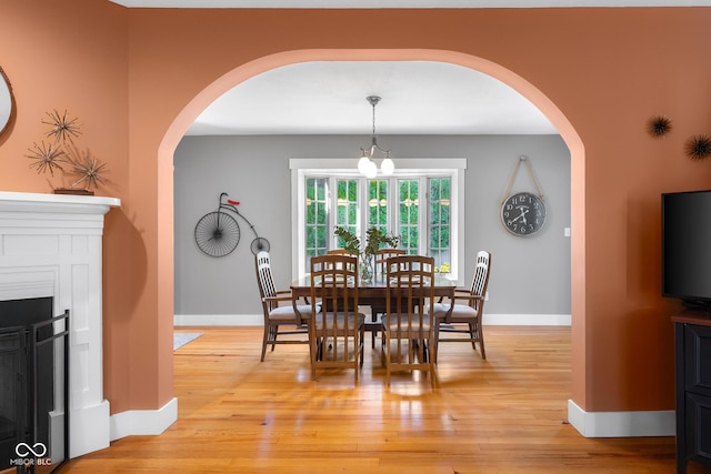 4224 River Rd, Columbus, IN 47203 - dining area featuring arched walkways, light wood finished floors, and a fireplace
