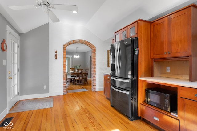4224 River Rd, Columbus, IN 47203 - kitchen featuring fridge with ice dispenser, black microwave, arched walkways, lofted ceiling, and light countertops