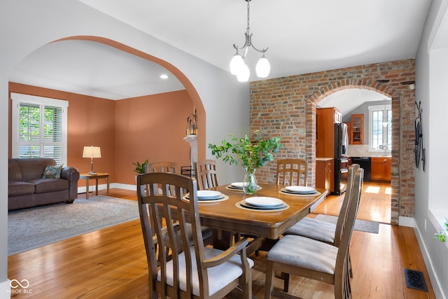 4224 River Rd, Columbus, IN 47203 - dining area featuring arched walkways, light wood-type flooring, and brick wall