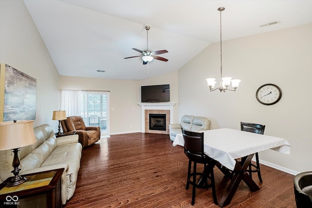 5651 Jones Dr, Plainfield, IN 46168 - dining space featuring lofted ceiling, a ceiling fan, dark wood-style flooring, a tiled fireplace, and a chandelier