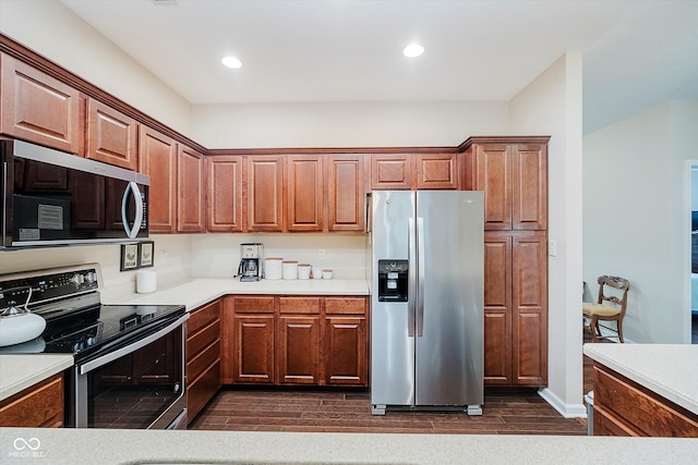 5651 Jones Dr, Plainfield, IN 46168 - kitchen featuring stainless steel appliances, dark wood-style floors, light countertops, recessed lighting, and brown cabinetry