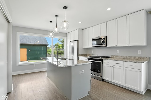 1905 Cornell Ave, Indianapolis, IN 46202 - kitchen with appliances with stainless steel finishes, light wood-style floors, an island with sink, white cabinets, and recessed lighting
