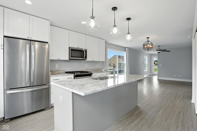 1905 Cornell Ave, Indianapolis, IN 46202 - kitchen featuring stainless steel appliances, light wood finished floors, white cabinets, decorative light fixtures, and recessed lighting