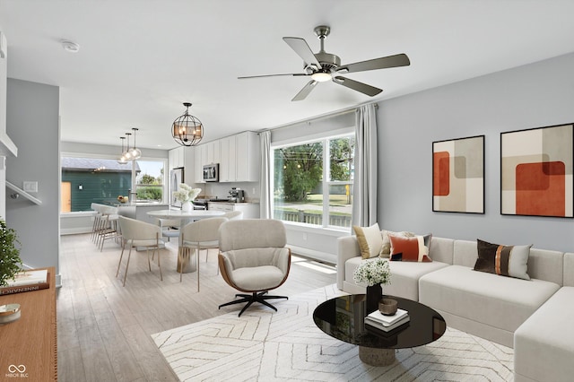 1905 Cornell Ave, Indianapolis, IN 46202 - living room featuring a chandelier, ceiling fan, and light wood-style floors