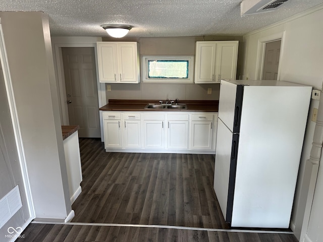 707 S Luick Ave, Muncie, IN 47302 - kitchen featuring freestanding refrigerator, white cabinetry, a textured ceiling, and dark wood finished floors