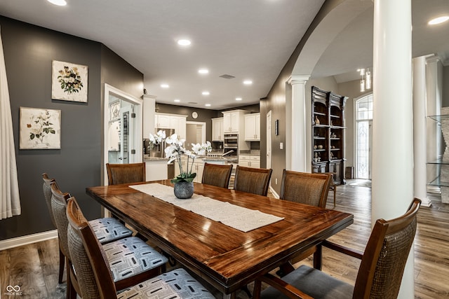 295 Watershed Ct, Noblesville, IN 46062 - dining space featuring decorative columns, arched walkways, wood finished floors, and recessed lighting