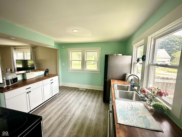 514 E 2nd St, Sheridan, IN 46069 - kitchen featuring butcher block countertops, electric range, white cabinets, wood finished floors, and recessed lighting