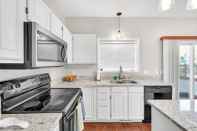 8642 Ray Cir, Indianapolis, IN 46256 - kitchen featuring black appliances, white cabinets, decorative light fixtures, light stone counters, and wood finished floors