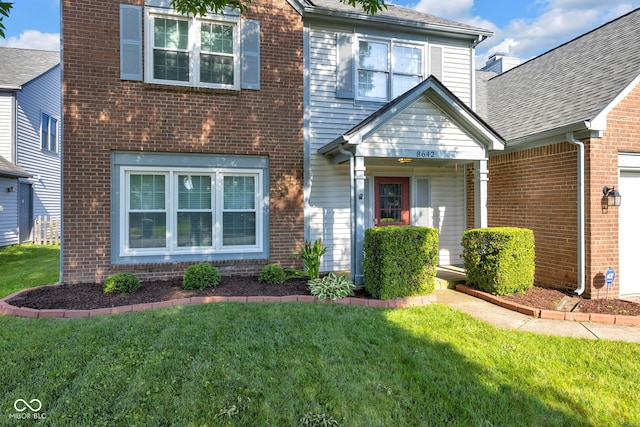 8642 Ray Cir, Indianapolis, IN 46256 - traditional home with brick siding, a front lawn, and a garage