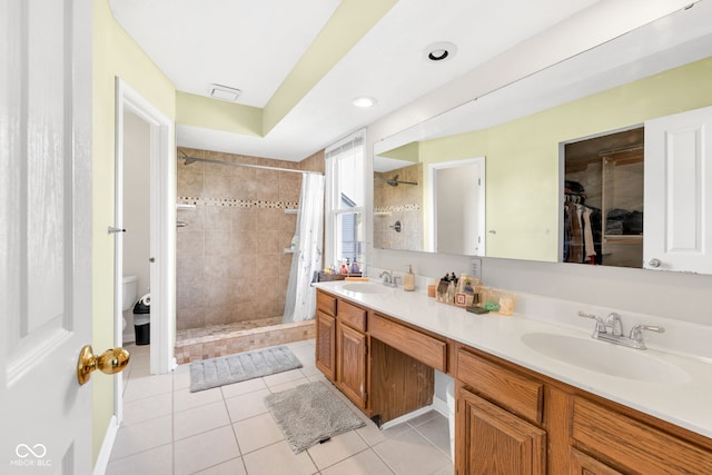 8642 Ray Cir, Indianapolis, IN 46256 - full bathroom featuring tiled shower, double vanity, tile patterned flooring, a walk in closet, and recessed lighting