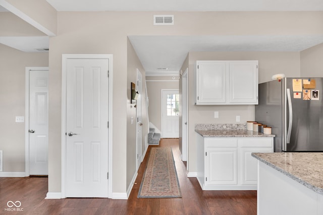 8642 Ray Cir, Indianapolis, IN 46256 - kitchen featuring freestanding refrigerator, white cabinets, dark wood-type flooring, and light stone countertops