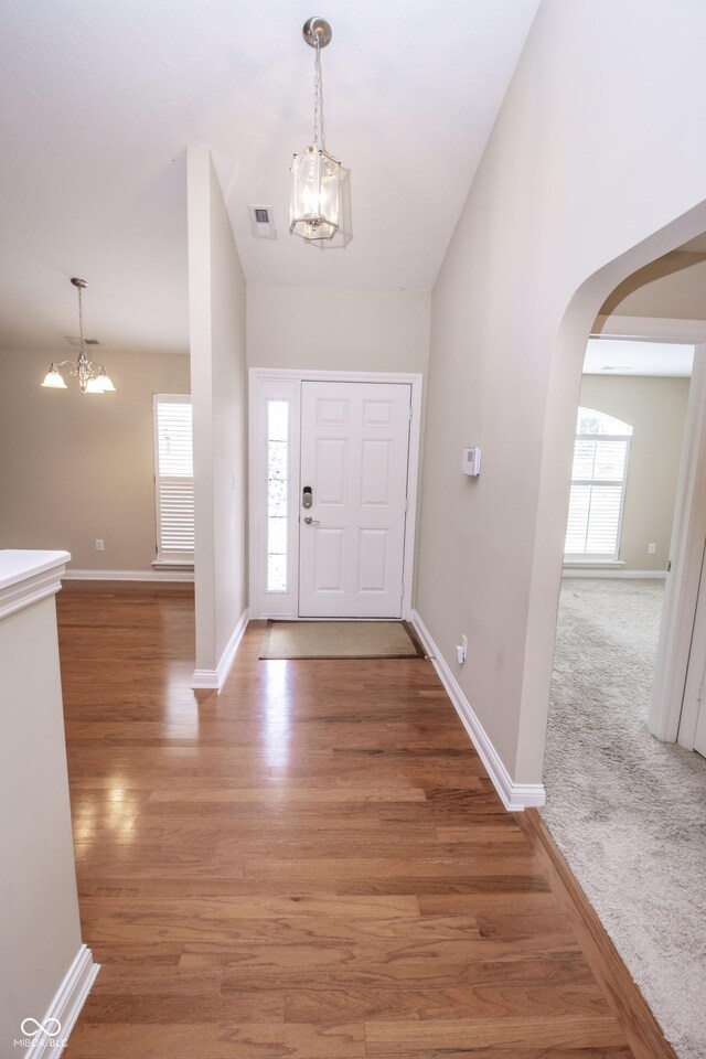 6448 W Whiteside Ct, Greenfield, IN 46140 - entryway with a chandelier, light wood-type flooring, and arched walkways