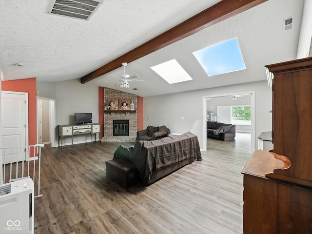 856 Cypress N, Greenwood, IN 46143 - living room with wood finished floors, ceiling fan, a brick fireplace, and a skylight