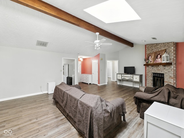 856 Cypress N, Greenwood, IN 46143 - living room featuring light wood-style floors, a brick fireplace, a skylight, and ceiling fan